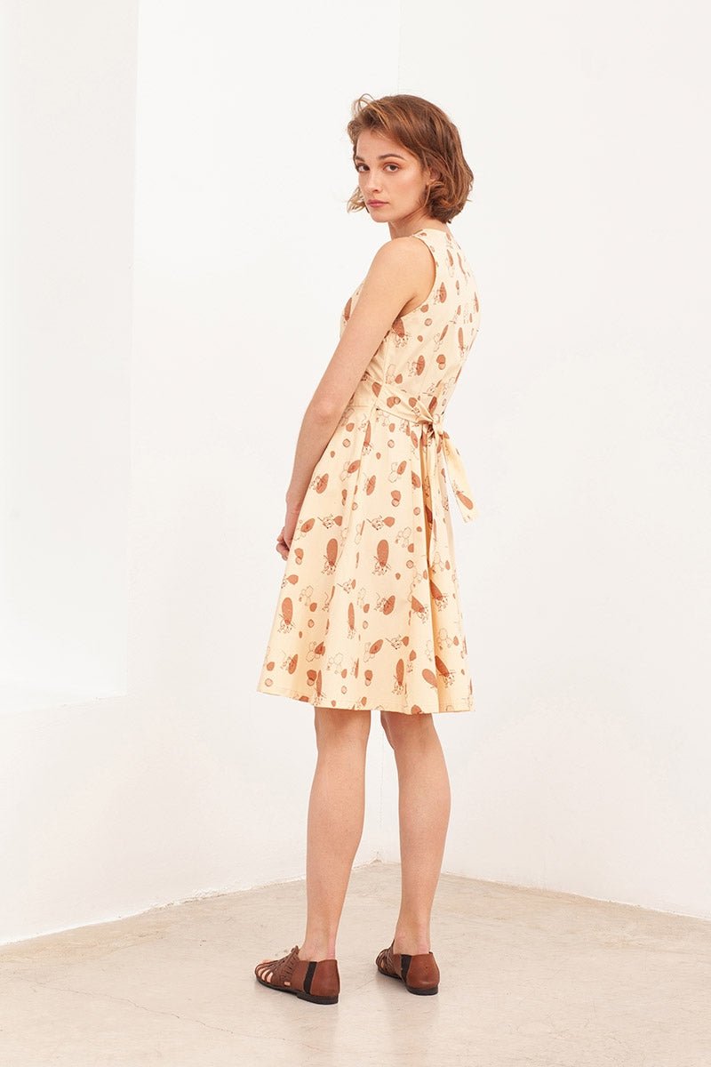 BEGA is a poplin belted wrap dress in beige.